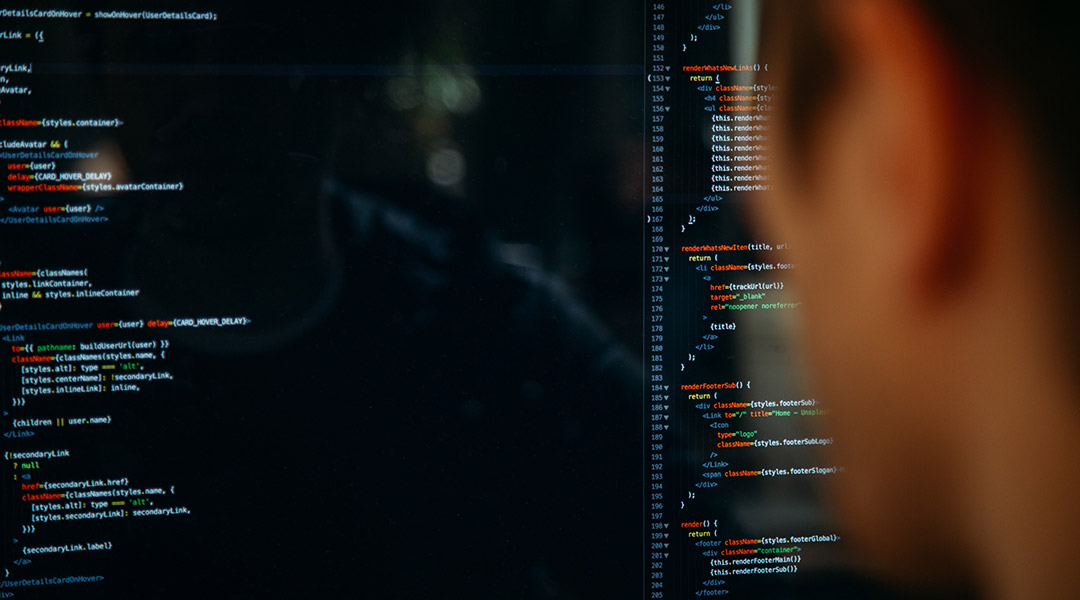 écran d'ordinateur avec du code informatique de couleur avec une tete qui regarde en premier plan DEVENSYS