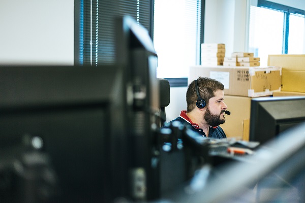 collaborateur de DEVENSYS derrière son ordinateur avec un casque en appel avec un client